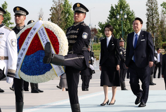 우즈베키스탄을 국빈 방문 중인 윤석열 대통령과 김건희 여사가 13일(현지시간) 타슈켄트 양기 우즈베키스탄 공원광장에 위치한 독립기념비를 방문해 헌화하고 있다.    2024.6.13  연합뉴스