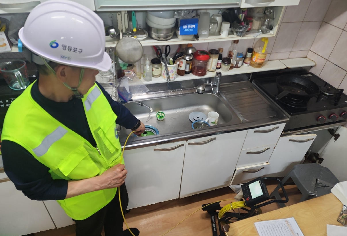 서울 영등포구가 위탁한 전문 업체 직원이 씽크대를 통해 배수설비를 점검하고 있다. 영등포구 제공