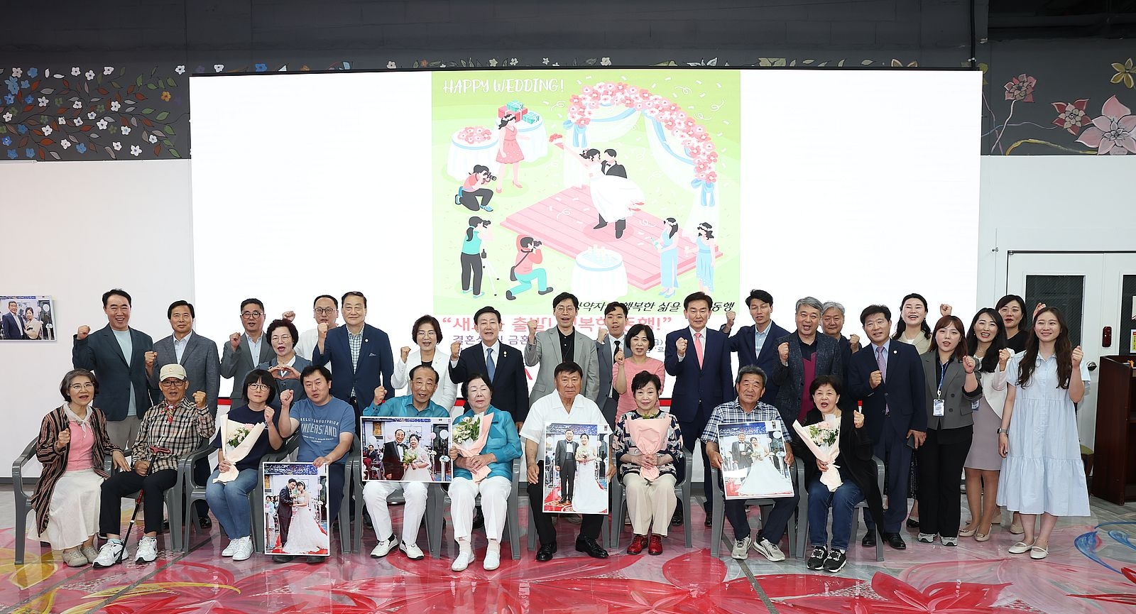 서울 은평구가 지난 14일 개최한 장애인 합동결혼식 기념식에서 참가자들이 결혼사진을 들고 환하게 웃고 있다. 은평구 제공