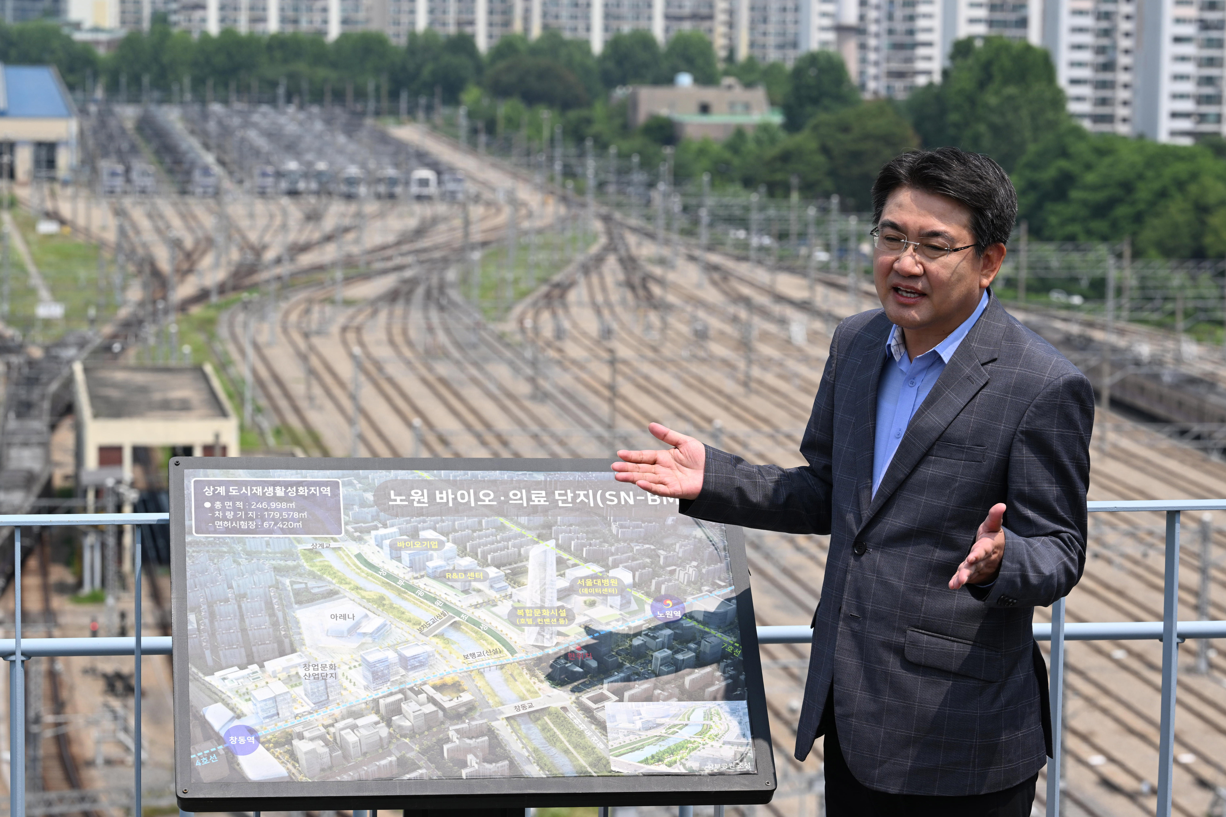 오승록 서울 노원구청장이 17일 노원구청 옥상 전망대에서 서울 디지털바이오시티(S DBC)로 개발이 추진 중인 창동차량기지를 가리키며 앞으로 바뀔 노원의 미래와 비전에 대해 설명하고 있다. 창동차량기지 뒤편으로 재건축을 앞둔 아파트 단지들이 보인다. 도준석 전문기자