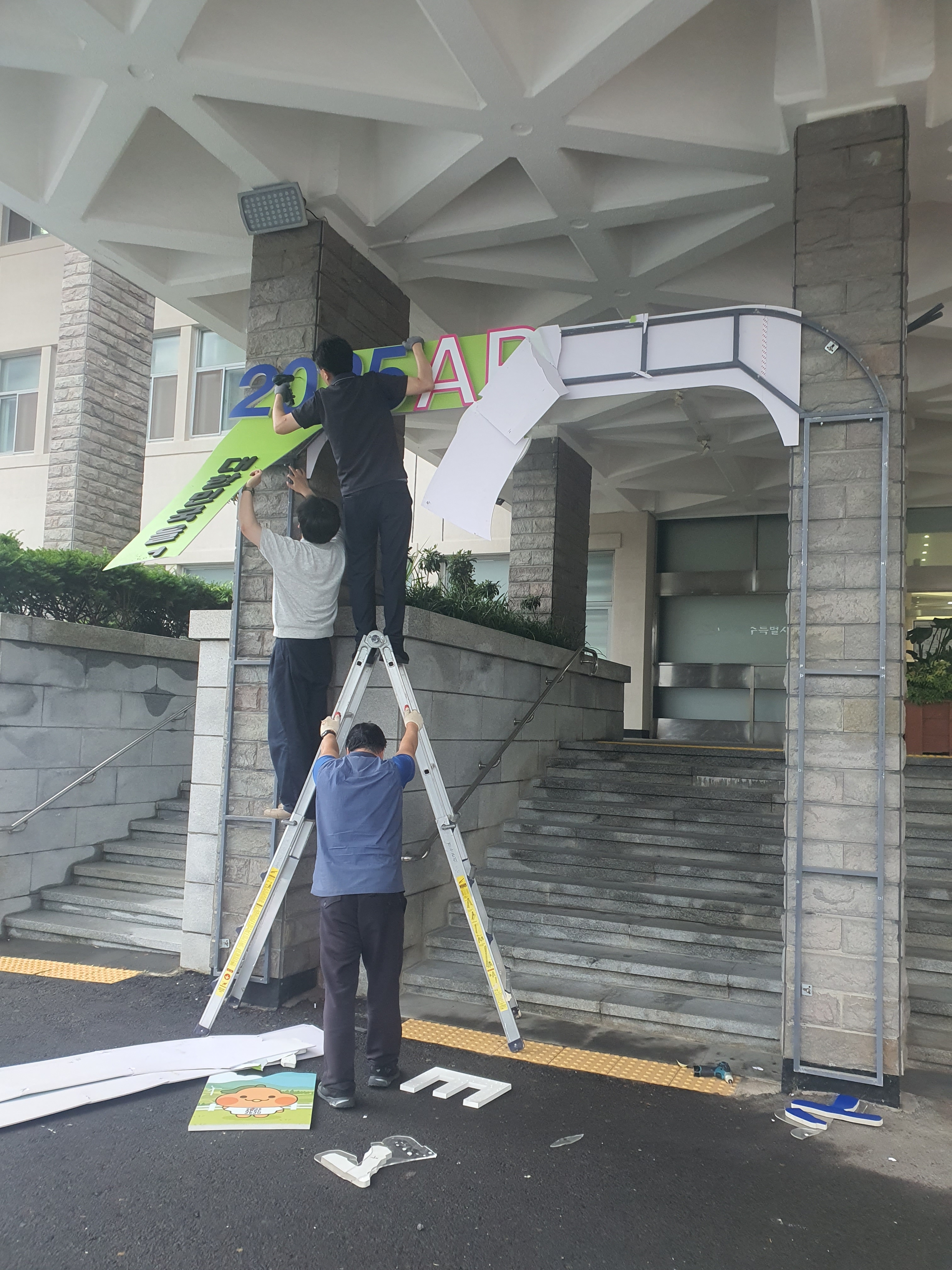 제주도청 본관 입구에 걸렸던 APEC 제주 유치 홍보판이 철거되고 있다. 독자 제공