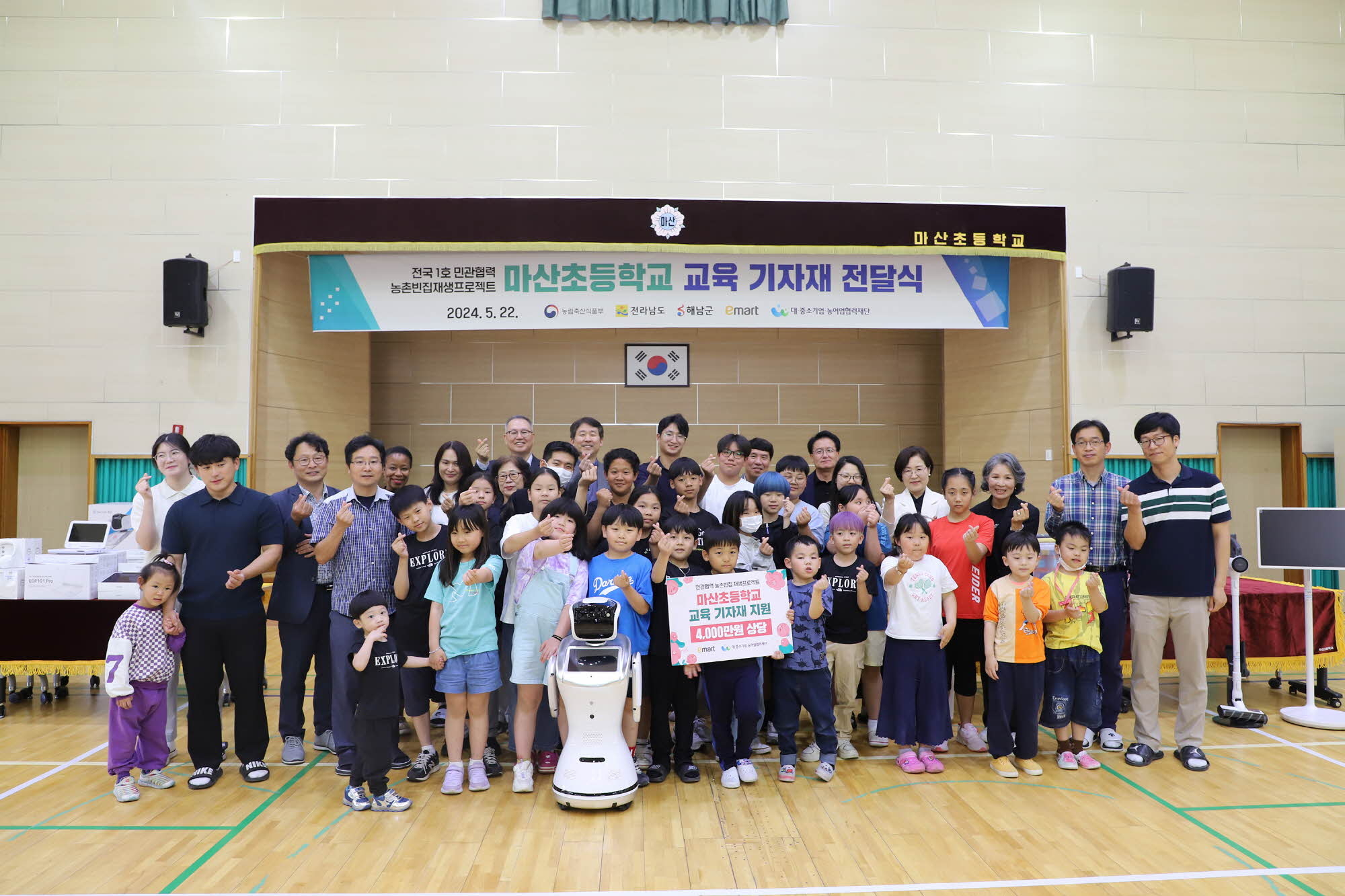 마산초등학교 교육 기자재 전달식에 참여한 행사 관계자 및 마산초 학생 등이 기념촬영을 하고 있다. 이마트 제공