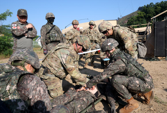 26일 강원 철원군 심일훈련장에서 열린 한미연합군사령부·합동참모본부·주한미군사령부 연합 의무지원 야외기동훈련(FTX)에서 육군 6사단 및 미 2사단, 한미연합사단 의무요원들이 부상자 응급처치를 실시하고 있다. 2024.6.26. 연합뉴스