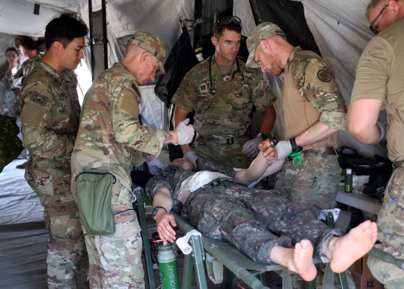 26일 강원 철원군 심일훈련장에서 열린 한미연합군사령부·합동참모본부·주한미군사령부 연합 의무지원 야외기동훈련(FTX)에서 육군 6사단 및 미 2사단, 한미연합사단 의무요원들이 부상자 응급처치를 실시하고 있다. 2024.6.26. 연합뉴스