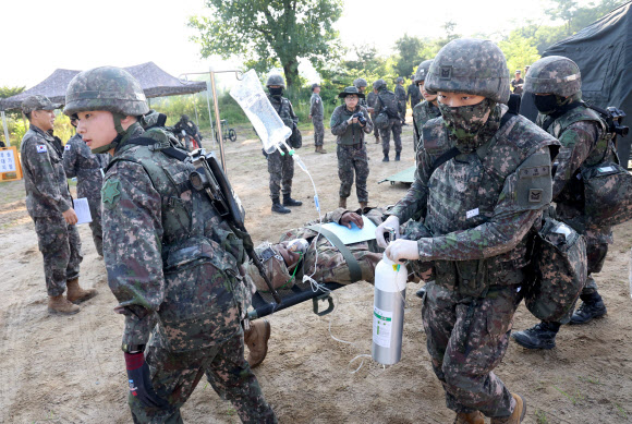 26일 강원 철원군 심일훈련장에서 열린 한미연합군사령부·합동참모본부·주한미군사령부 연합 의무지원 야외기동훈련(FTX)에서 육군 6사단 및 미 2사단, 한미연합사단 의무요원들이 부상자 응급처치를 실시하고 있다. 2024.6.26. 연합뉴스