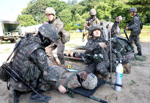 26일 강원 철원군 심일훈련장에서 열린 한미연합군사령부·합동참모본부·주한미군사령부 연합 의무지원 야외기동훈련(FTX)에서 육군 6사단 및 미 2사단, 한미연합사단 의무요원들이 부상자 응급처치를 실시하고 있다. 2024.6.26. 연합뉴스
