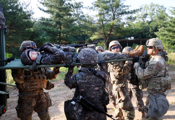 26일 강원 철원군 심일훈련장에서 열린 한미연합군사령부·합동참모본부·주한미군사령부 연합 의무지원 야외기동훈련(FTX)에서 육군 6사단 및 미 2사단, 한미연합사단 의무요원들이 부상자 응급처치를 실시하고 있다. 2024.6.26. 연합뉴스
