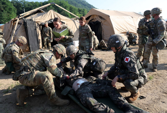 26일 강원 철원군 심일훈련장에서 열린 한미연합군사령부·합동참모본부·주한미군사령부 연합 의무지원 야외기동훈련(FTX)에서 육군 6사단 및 미 2사단, 한미연합사단 의무요원들이 부상자 응급처치를 실시하고 있다. 2024.6.26. 연합뉴스