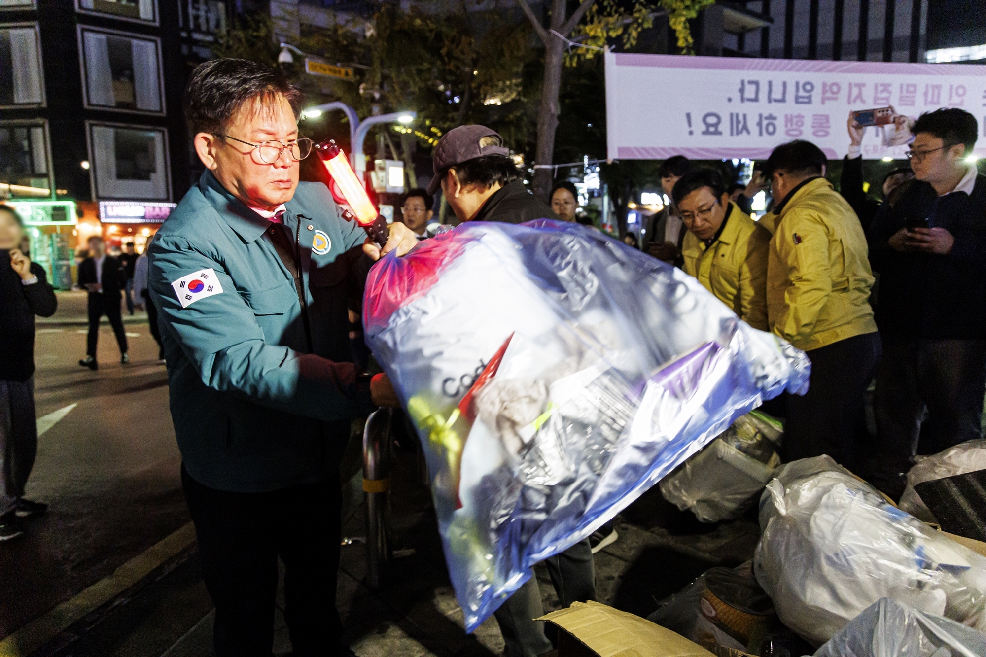 박강수(왼쪽) 서울 마포구청장이 지난해 10월, 핼러윈 인파밀집 안전관리를 하며 통행에 방해가 되는 쓰레기를 치우고 있다. 마포구 제공