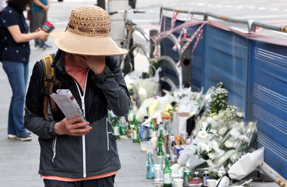 4일 오전 서울 중구 시청역 인근 역주행 사고 현장에서 한 추모객이 추모를 마친 뒤 눈물을 닦으며 지나가고 있다. 지난 1일 해당 교차로에서는 운전자 A씨가 몰던 승용차가 역주행하며 인도로 돌진해 9명이 사망했다. 2024.7.4 연합뉴스