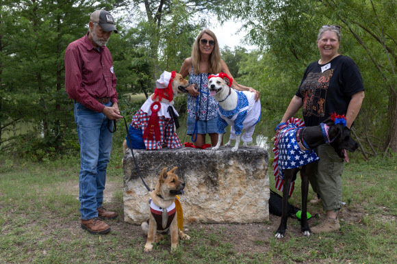 Residents pose with their dogs after the city?s 28th annual Pet Parade during Fourth of July Independence Day celebrations in Bandera, Texas, U.S., July 4, 2024. REUTERS 연합뉴스