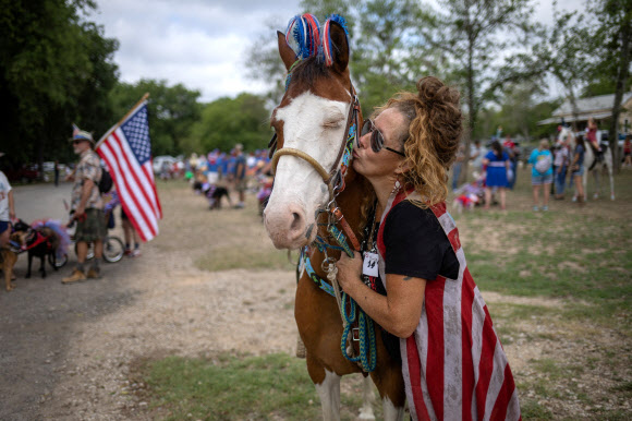 Squirt Gun, a seven year old American Paint Horse, closes its eyes as its kissed by local resident Vanessa Williams before the start of the city‘s 28th annual Pet Parade during Fourth of July Independence Day celebrations in Bandera, Texas, U.S., July 4, 2024. REUTERS 연합뉴스