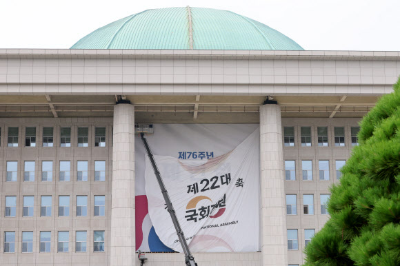 서울 여의도 국회의사당 본관에 설치된 제22대 국회 개원 현수막이 7일 오후 철거되고 있다.  5일 열릴 예정됐던 22대 국회 개원식은 ‘채상병특검법’을 둘러싼 여야 충돌의 여파로 무기한 연기됐다. 2024.7.7  연합뉴스