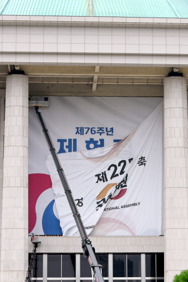 서울 여의도 국회의사당 본관에 설치된 제22대 국회 개원 현수막이 7일 오후 철거되고 있다.   5일 열릴 예정됐던 22대 국회 개원식은 ‘채상병특검법’을 둘러싼 여야 충돌의 여파로 무기한 연기됐다. 2024.7.7  연합뉴스