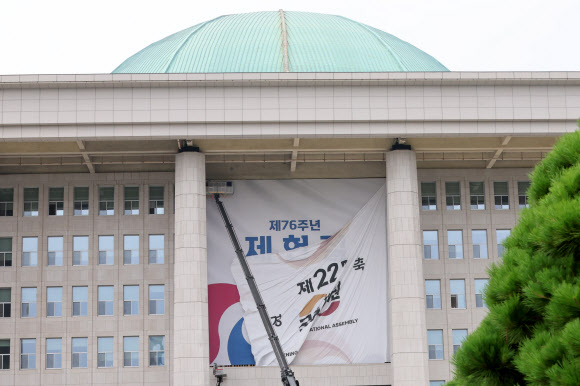서울 여의도 국회의사당 본관에 설치된 제22대 국회 개원 현수막이 7일 오후 철거되고 있다.   5일 예정됐던 22대 국회 개원식은 ‘채상병특검법’을 둘러싼 여야 충돌의 여파로 무기한 연기됐다. 2024.7.7  연합뉴스