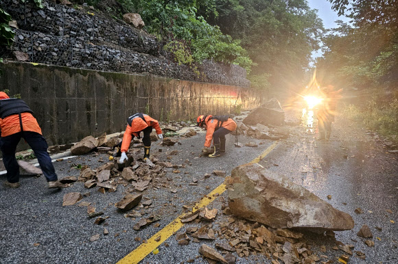 8일 경북 북부지역에 많은 비가 내린 가운데 안동시 예안면 한 도로에 돌과 흙이 쏟아져 소방관들이 치우고 있다. 2024.7.8  경북소방본부 제공