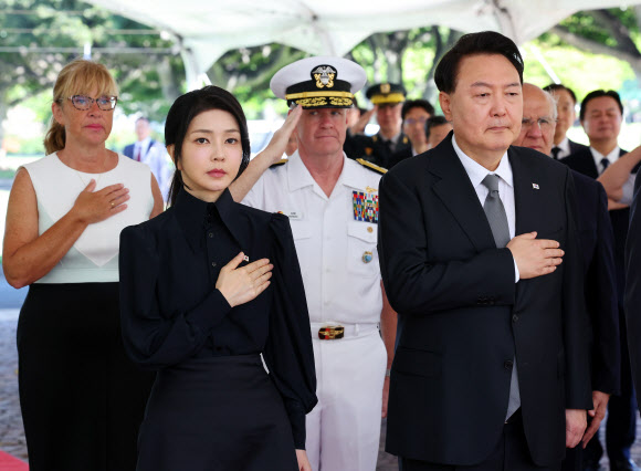 윤석열 대통령과 김건희 여사가 8일(현지시간) 미국 하와이 태평양국립묘지(펀치볼)를 방문, 애국가가 연주되는 동안 국기에 경례하고 있다.  2024.7.9  연합뉴스