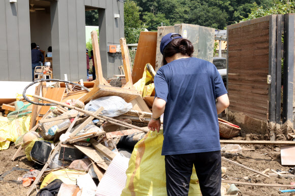 침수 피해로 버려진 짐을 바라보는 주민