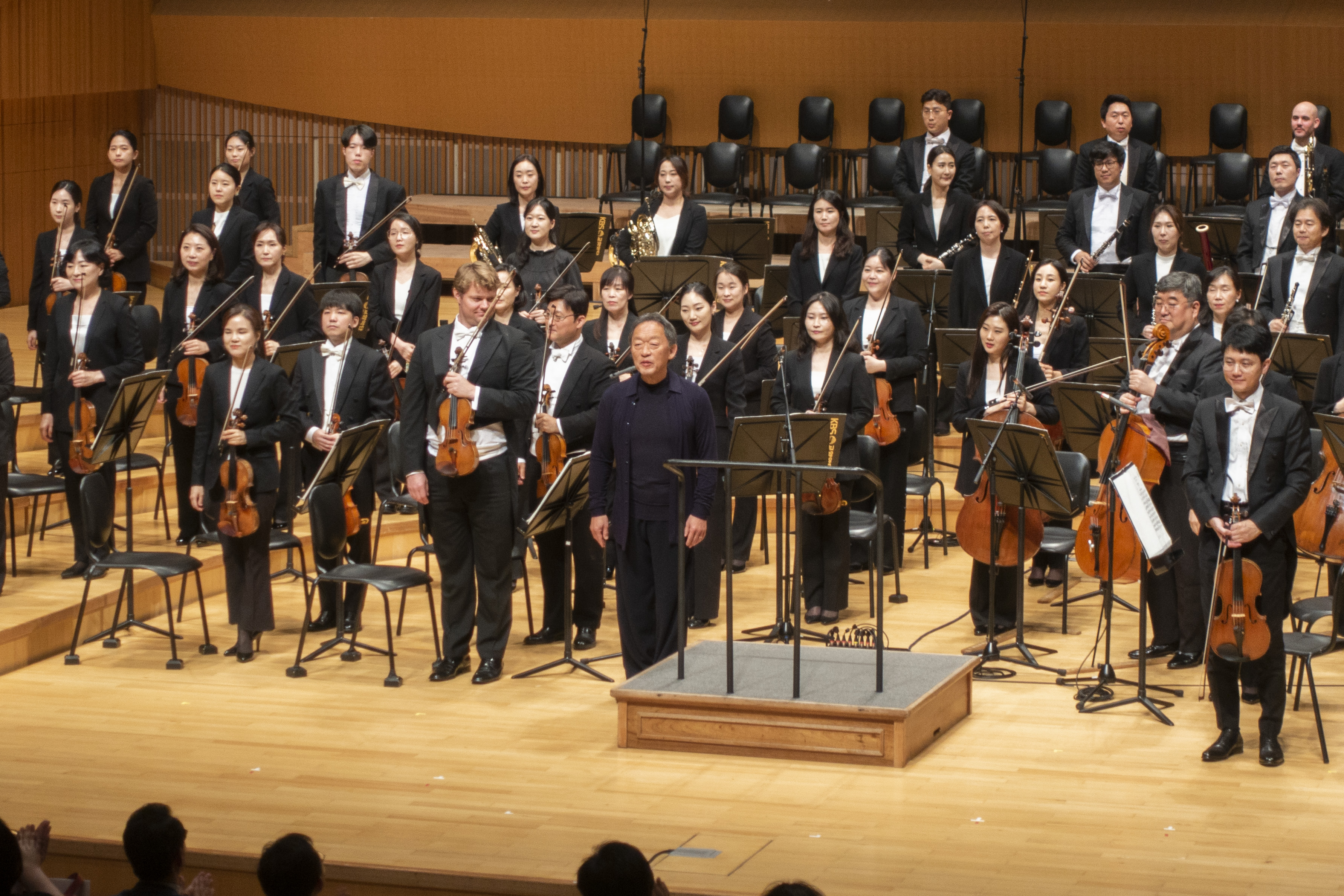 정명훈이 12일 서울 송파구 롯데콘서트홀에서 열린 KBS교향악단 연주회에서 단원들과 함께 인사하고 있다. 류재민 기자