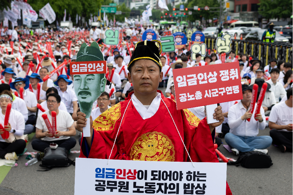 6일 오후 정부서울청사 인근에서 열린 공무원 임금인상 쟁취 총궐기대회에서 한 참석자가 관련 손 피켓을 들고 있다. 2024.7.6 연합뉴스