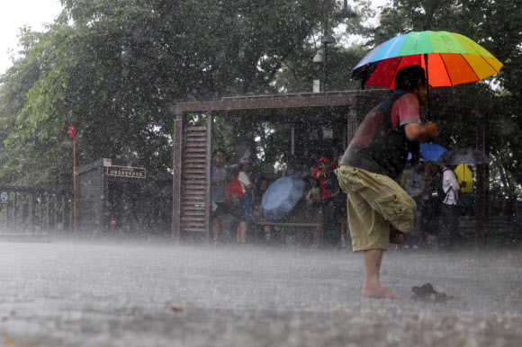 전국 곳곳에 비가 내린 16일 오후 서울 남산을 찾은 시민이 신발을 벗고 있다. 2024.7.16. 연합뉴스