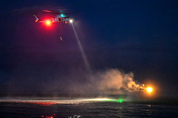 공군 제6탐색구조비행전대가 지난 17일 강원 강릉시 인근 동해상에서 전술 임무 집중훈련을 연계한 ‘야간 수상 수중 전투탐색구조훈련’을 실시했다고 18일 밝혔다. 사진은 항공구조사들이 조난 조종사에게 다가가기 위해 호이스트를 타고 하강하는 모습. 2024.7.18  공군 제공