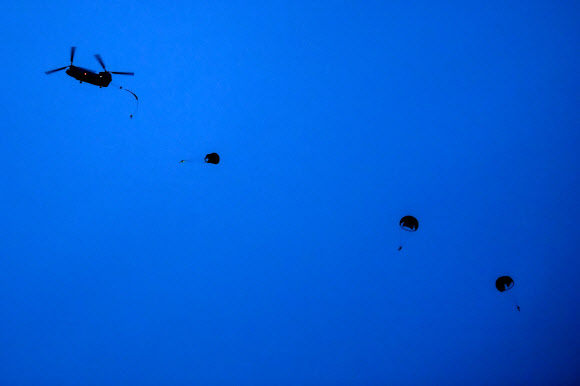 공군 제6탐색구조비행전대가 지난 17일 강원 강릉시 인근 동해상에서 전술 임무 집중훈련을 연계한 ‘야간 수상 수중 전투탐색구조훈련’을 실시했다고 18일 밝혔다. 사진은 항공구조사들이 해상에서 조난된 조종사를 구출하기 위해 HH-47 탐색구조헬기에서 줄지어 강하하며 공중으로 침투하는 모습. 2024.7.18  공군 제공