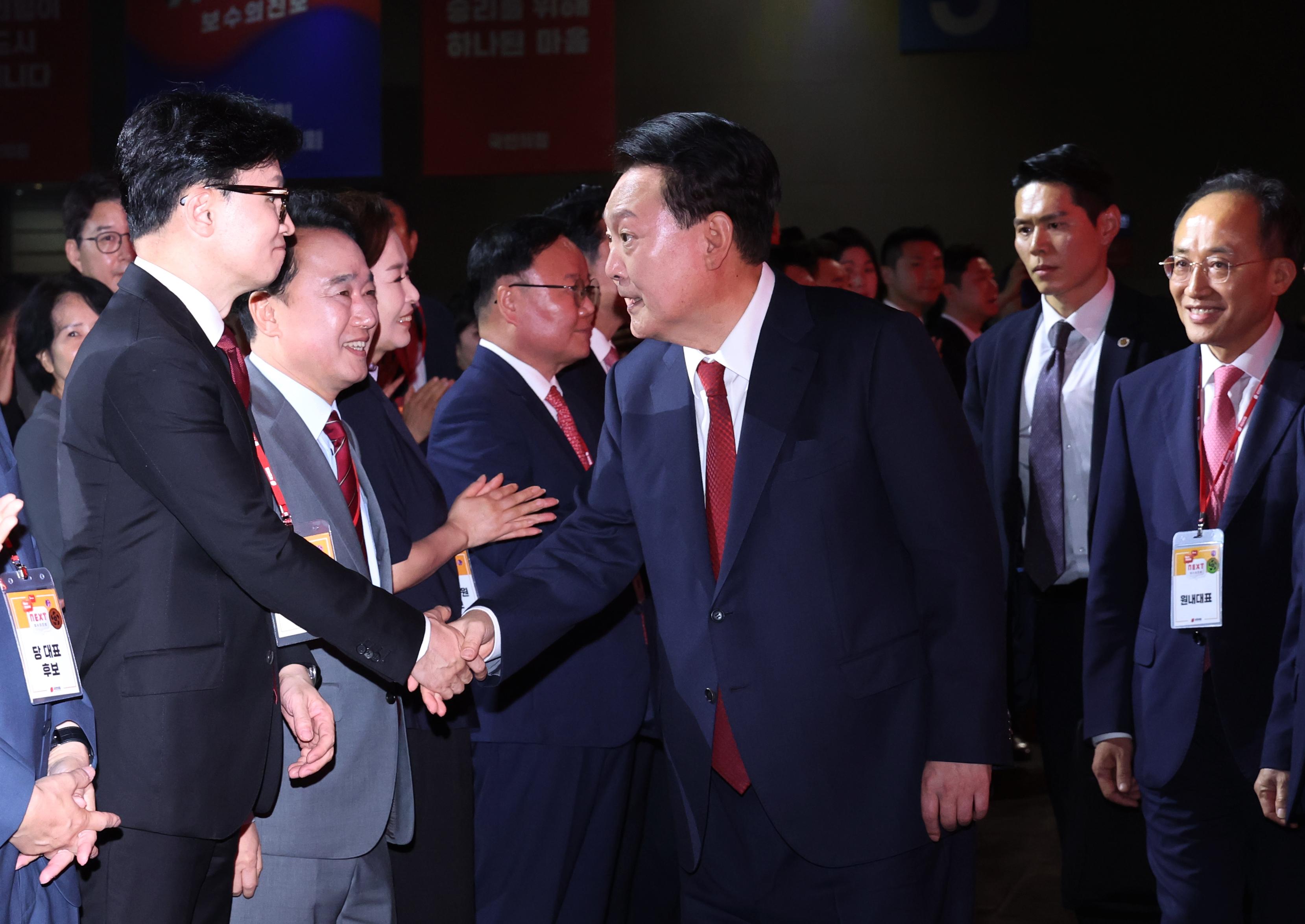 윤석열 대통령이 23일 오후 경기 고양시 킨텍스에서 열린 국민의힘 제4차 전당대회에 입장하면서 한동훈 신임 당대표와 악수하고 있다. 연합뉴스