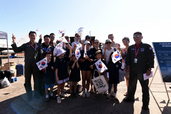 한국 공군 F-15K 조종사가 지난 20일 호주 다윈기지 주기장 일대에서 열린 피치블랙 오픈데이(Open Day) 행사에서 대한민국 공군 부스를 방문한 호주 다윈 한인회 및 교민 자녀들과 기념 촬영하고 있다. 2024.7.24 공군 제공