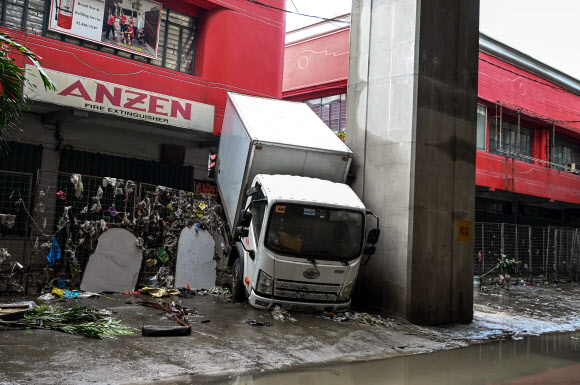 TOPSHOT - A truck is seen stuck in a fence in the aftermath of Typhoon Gaemi in Manila on July 25, 2024. AFP 연합뉴스