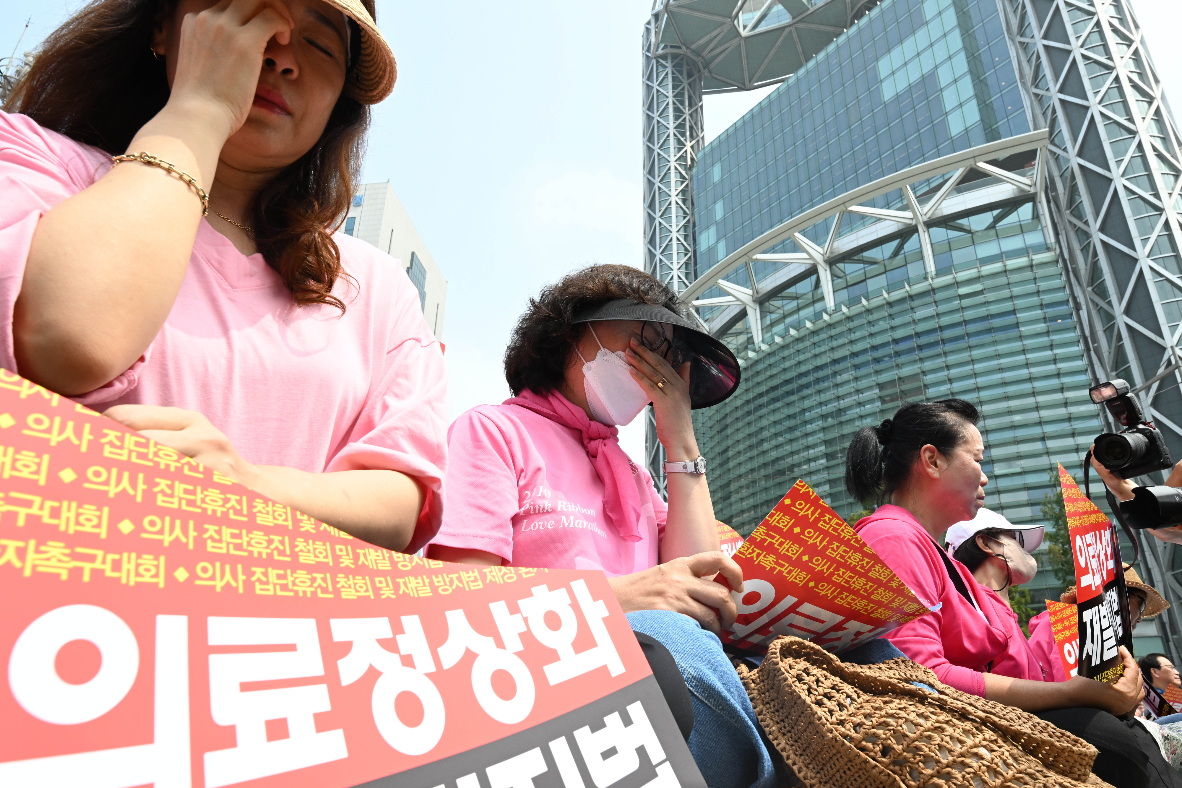 한국환자단체연합회, 한국유방암환우총연합회, 한국희귀·난치성질환연합회 등 환자 단체 회원들이 4일 서울 종로구 보신각 앞에서 의사 집단휴진 철회와 재발방지법 제정을 촉구하는 가운데 참가자들이 코넬리아드랑게 증후군 환자의 어머니인 김정애 씨의 발언을 들으며 눈물을 흘리고 있다. 2024.7.4 홍윤기 기자