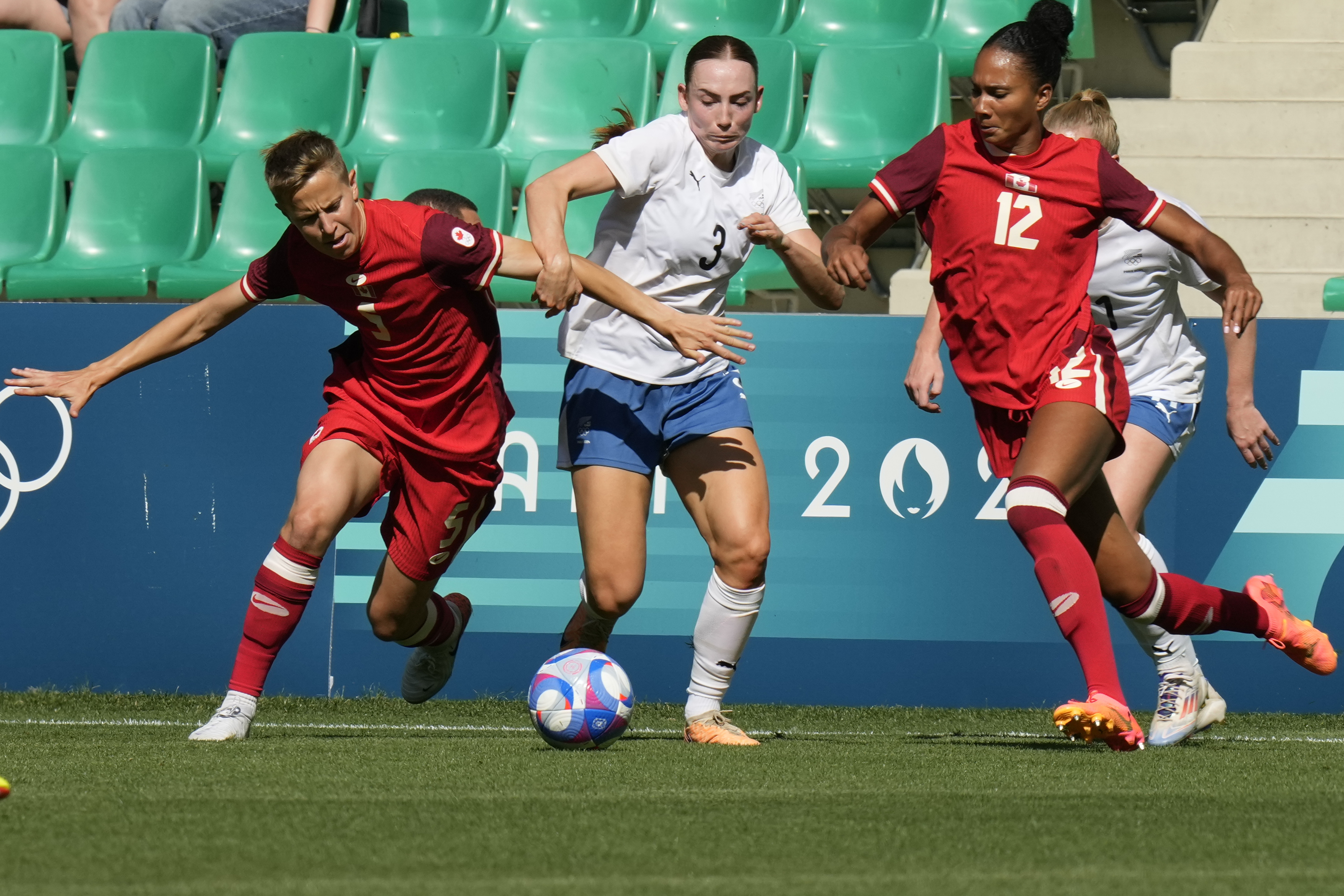 지난 26일 0시(한국시간) 2024 파리 올림픽 여자 축구 A조 1차전에서 뉴질랜드의 매켄지 배리(가운데)가 캐나다의 퀸(왼쪽)과 제이드 로즈(오른쪽)를 상대로 공을 다투고 있다. AP 연합뉴스