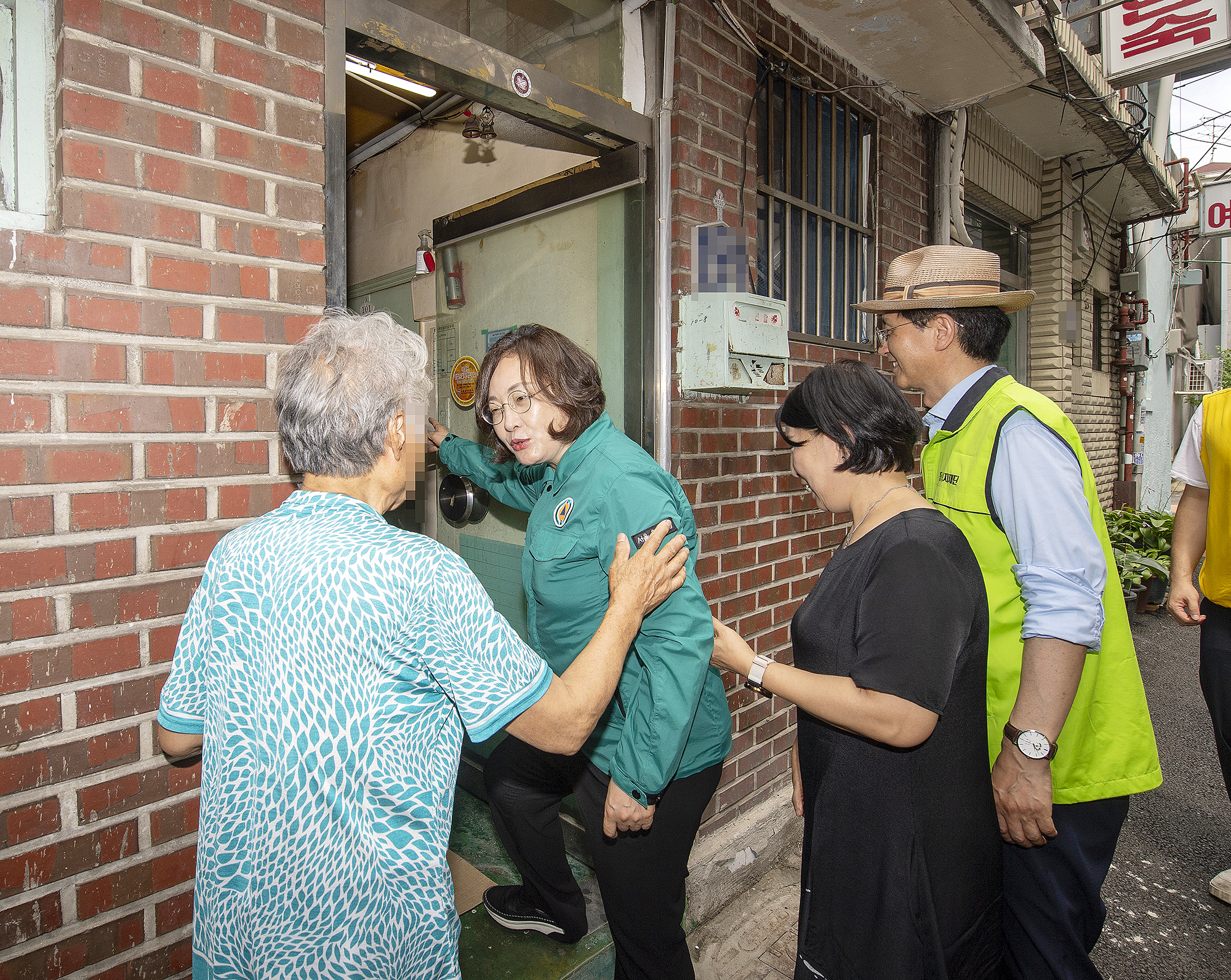 지난 24일 서울 용산구 동자동 쪽방촌을 찾은 박희영(왼쪽 두번째) 용산구청장이 쪽방촌 여인숙 주민과 이야기를 하고 있다. 용산구 제공