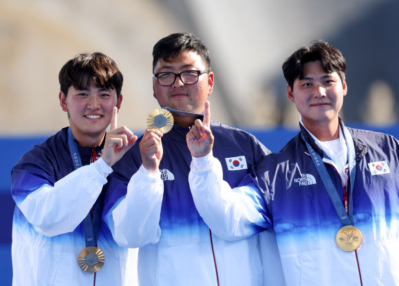 이우석(오른쪽부터), 김우진, 김제덕이 29일(현지시간) 프랑스 파리 레쟁발리드 양궁 경기장에서 열린 2024 파리올림픽 양궁 남자 단체 결승 시상식에서 금메달과 함께 기념 촬영을 하고 있다.  2024.7.30  연합뉴스