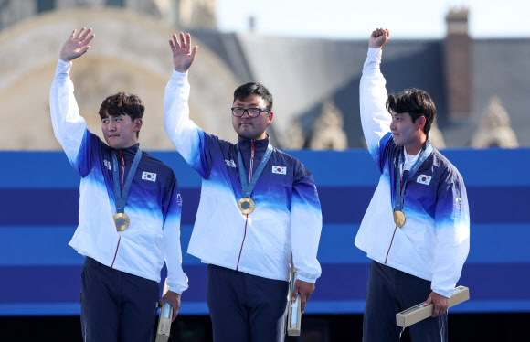 29일(현지시간) 프랑스 파리 레쟁발리드 양궁 경기장에서 열린 2024 파리올림픽 양궁 남자 단체 결승전에서 프랑스를 꺾고 우승한 한국 대표팀 선수들이 금메달을 목에 걸고 손을 흔들고 있다. 2024.7.30  연합뉴스