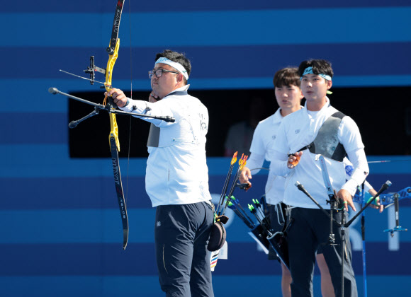 김우진이 29일(현지시간) 프랑스 파리 레쟁발리드 양궁 경기장에서 열린 2024 파리올림픽 양궁 남자 단체 결승전 한국과 프랑스의 경기에서 과녁을 향해 활을 쏘고 있다. 오른쪽부터 이우석, 김제덕. 2024.7.30  연합뉴스