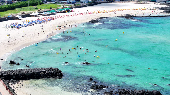 폭염특보가 내려진 30일 오전 제주시 애월읍 곽지해수욕장을 찾은 피서객이 물놀이를 하고 있다. 2024.7.30  연합뉴스