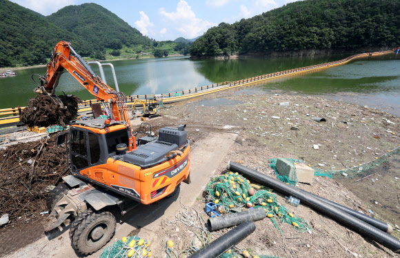 폭염경보가 발효된 5일 충북 옥천군 군북면 추소리 대청호에서 작업자들이 집중호우로 떠밀려 온 쓰레기를 수거하고 있다. 2024.8.5  연합뉴스
