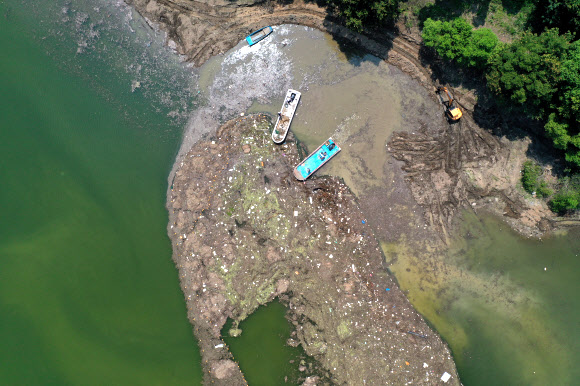 폭염경보가 발효된 5일 충북 옥천군 군북면 추소리 대청호에서 작업자들이 집중호우로 떠밀려 온 쓰레기를 수거하고 있다. 2024.8.5  연합뉴스