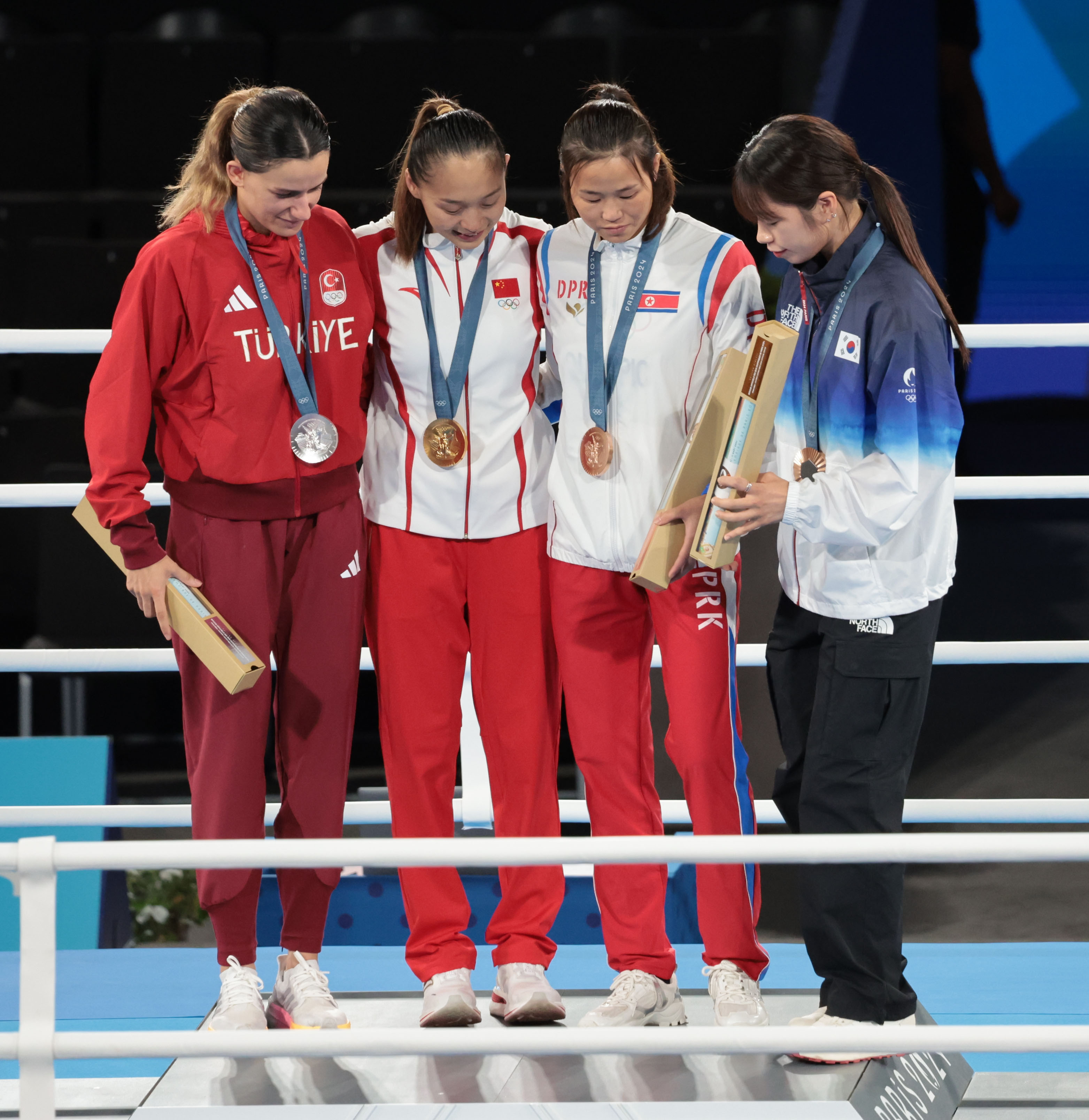 8일(현지시간) 프랑스 파리 롤랑가로스 경기장에서 열린 2024 파리 올림픽 복싱 여자 54㎏급 메달 수여식 후 ‘셀카 세리머니’를 할 때 우리나라 임애지(맨 오른쪽)가 금메달리스트 단상에 바로 올라가지 못하고 머뭇거리자 북한 방철미(오른쪽 두 번째)가 올라오라는 손짓을 하고 있다. 2024.8.9 연합뉴스