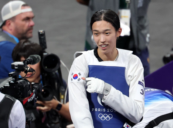 8일(현지시간) 프랑스 파리 그랑팔레 태권도경기장에서 열린 2024 파리올림픽 태권도 여자 57kg급 결승에서 한국의 김유진이 이란의 나히드 키야니찬데를 꺾고 금메달을 확정한 뒤 도복의 태극기를 가리키고 있다. 2024.8.9  연합뉴스