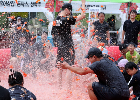 제13회 강원 횡성 둔내고랭지토마토축제 개막 첫날인 8일 참가자들이 둔내종합체육공원에 마련된 대형 토마토 풀장에서 토마토 속에 숨겨진 금반지 등 경품을 찾으려고 토마토를 던지고 으깨며 축제를 만끽하고 있다. ‘대한민국 최고의 토마토와 함께하는 가족축제’를 주제로 한 올해 축제는 오는 11일까지 이어진다. 2024.8.9  연합뉴스