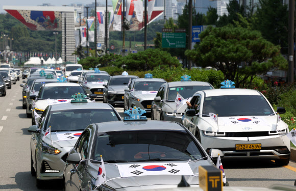 송파구청이 송파모범운전자회와 함께 13일 오전 서울 송파구 올림픽공원 인근에서 ‘호국영웅택시 카퍼레이드’를 열고 있다. 2024.8.13. 연합뉴스