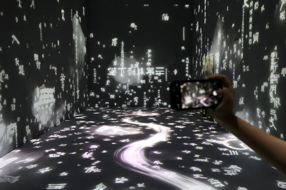 13일 오후 서울 중구 DDP에서 간송미술관 미디어 전시 ‘구름이 걷히니 달이 비치고 바람 부니 별이 빛난다’ 간담회 참석자가 전시를 둘러보고 있다. 2024.8.13. 연합뉴스