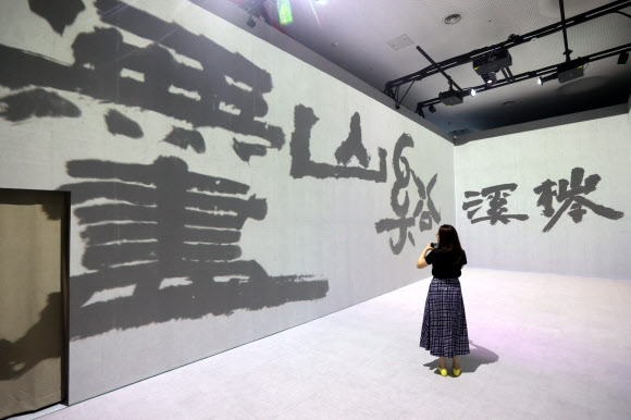 13일 오후 서울 중구 DDP에서 간송미술관 미디어 전시 ‘구름이 걷히니 달이 비치고 바람 부니 별이 빛난다’ 간담회 참석자가 전시를 둘러보고 있다. 2024.8.13. 연합뉴스