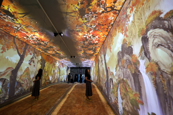 13일 오후 서울 중구 DDP에서 간송미술관 미디어 전시 ‘구름이 걷히니 달이 비치고 바람 부니 별이 빛난다’ 간담회 참석자가 전시를 둘러보고 있다. 2024.8.13. 연합뉴스