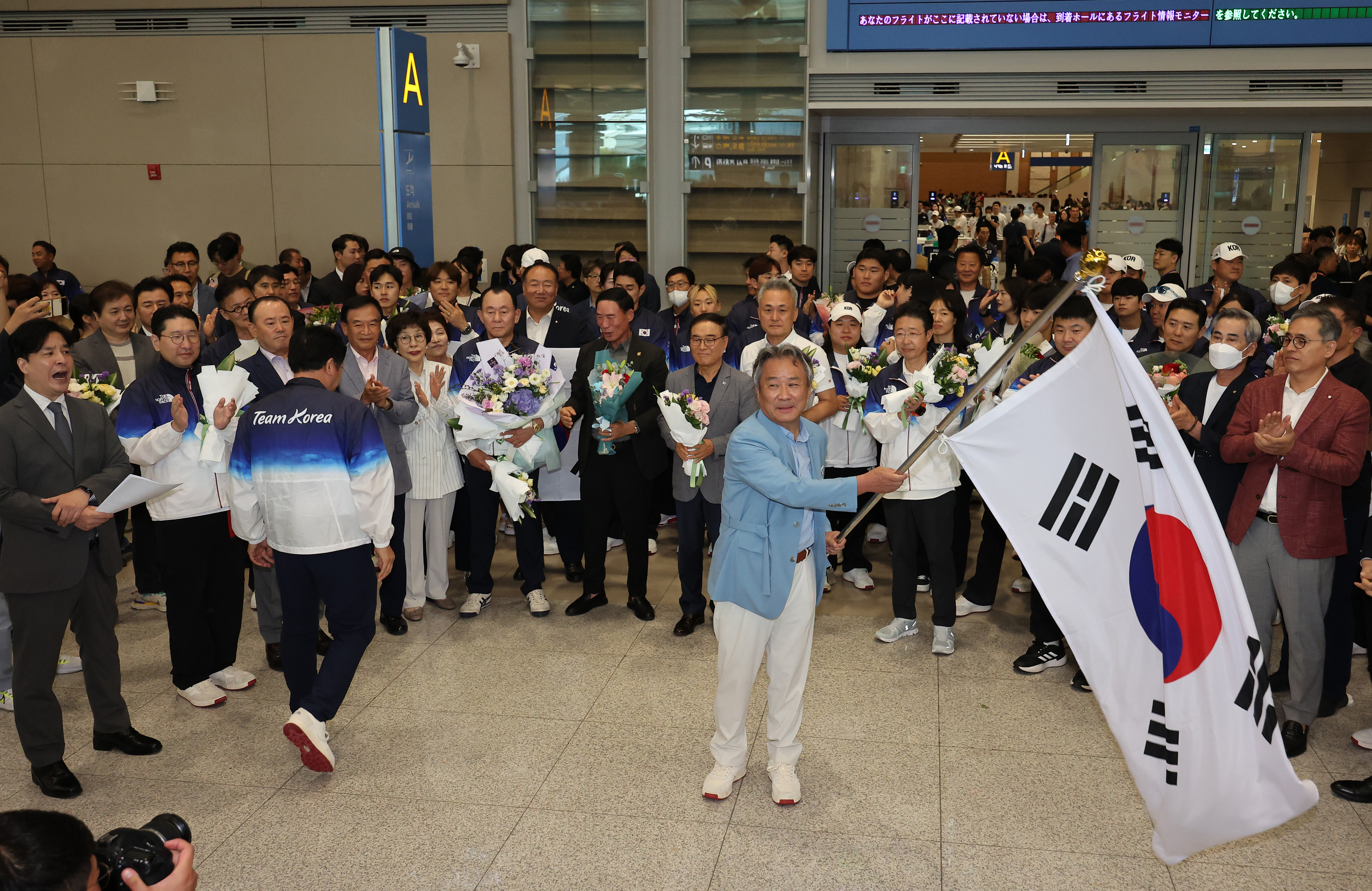 이기흥 대한체육회장이 13일 오후 인천국제공항 제2여객터미널을 통해 귀국해 태극기를 휘날리고 있다. 2024.8.13 연합뉴스