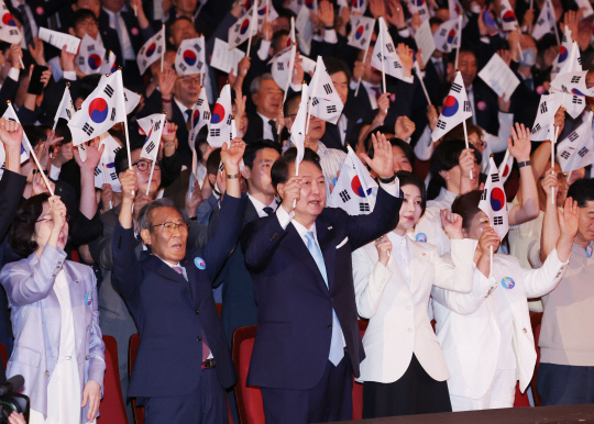 윤석열 대통령과 김건희 여사가 15일 서울 종로구 세종문화회관에서 열린 제79주년 광복절 경축식에서 이동일 순국선열유족회장 등 참석자들과 만세삼창을 하고 있다. 연합뉴스