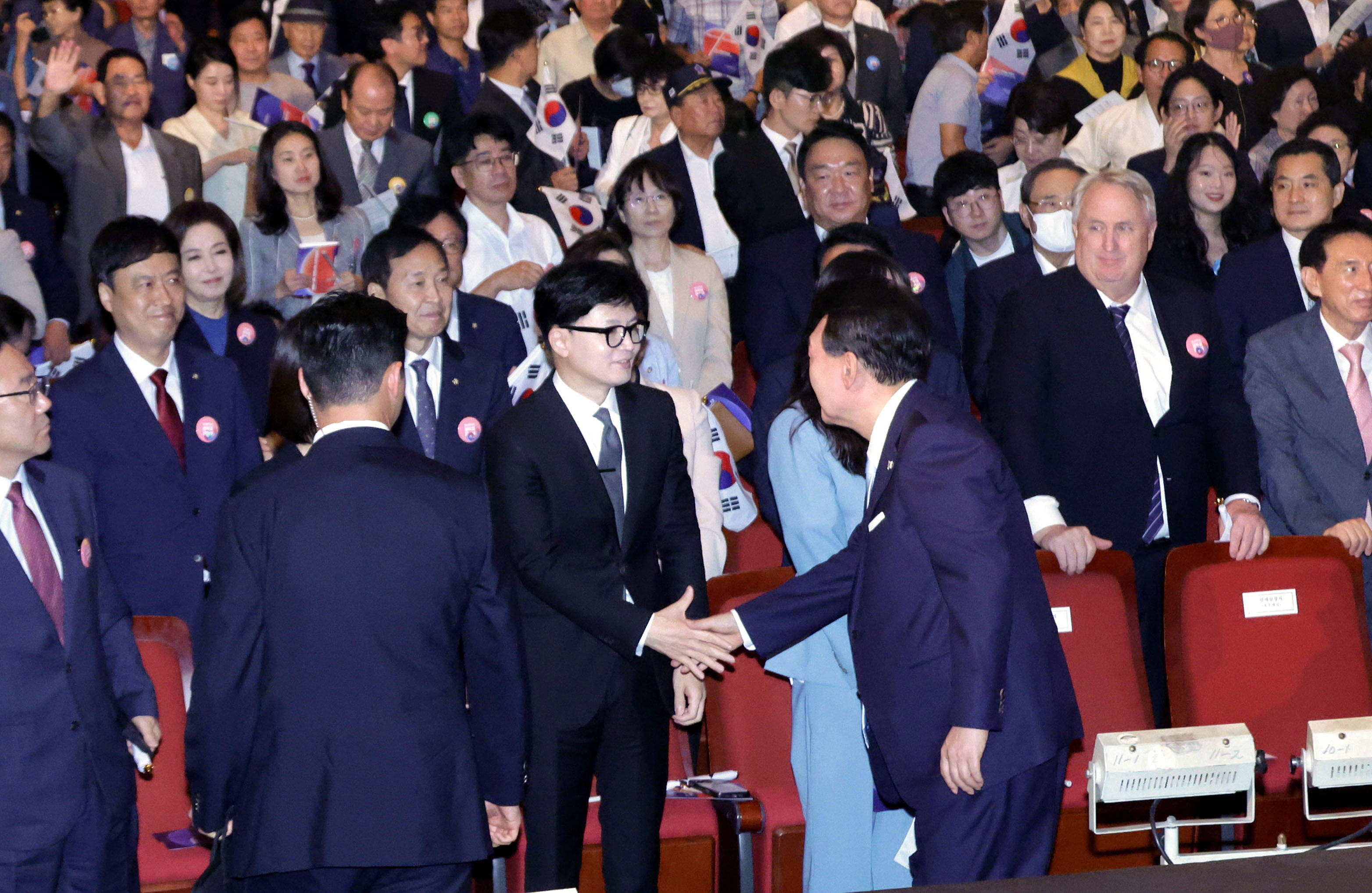 윤석열 대통령이 15일 서울 종로구 세종문화회관에서 열린 제79주년 광복절 경축식에서 한동훈 국민의힘 대표와 악수하고 있다.  연합뉴스