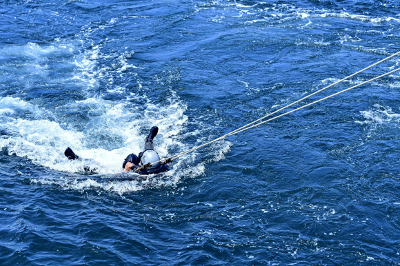 공군이 지난 14일 경남 해상생환훈련장에서 조종사 해상생환훈련을 실시했다고 17일 밝혔다. 사진은 공군 교관이 취재진에게 낙하산 견인 훈련 시범을 보이는 모습. 2024.8.17  공군 제공